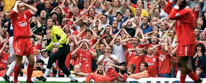 Torcedores do Liverpool levando as mãos à cabeça com o gol perdido por seu atacante Michael Owen.