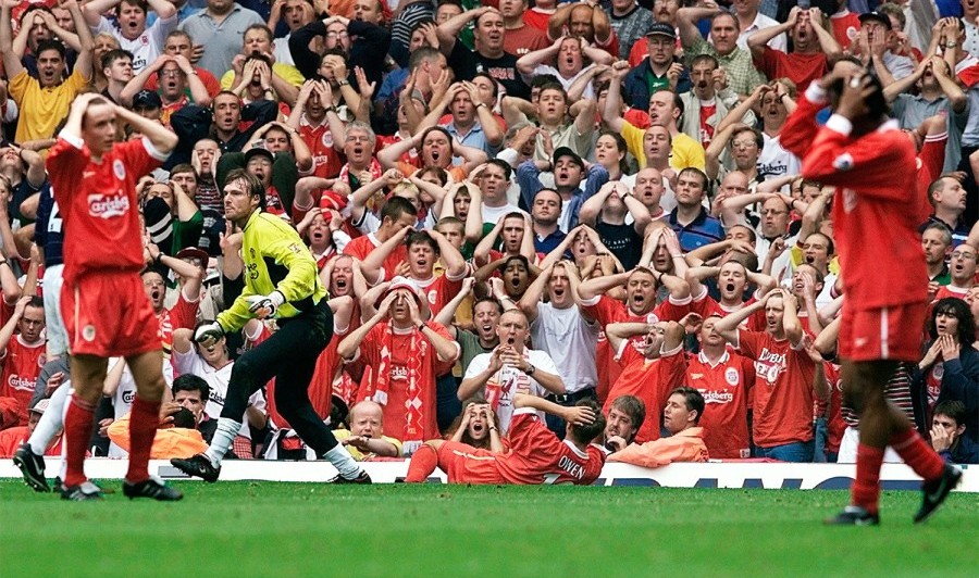 Torcedores do Liverpool levando as mãos à cabeça com o gol perdido por seu atacante Michael Owen.