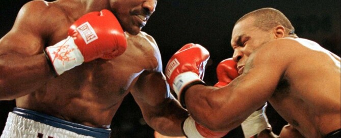 Foto do confronto histórico entre os pugilistas peso-pesados Evander Holyfield e Mike Tyson. Ilustra a famosa frase de Tyson, dizendo que "todo mundo tem um plano até levar um soco na cara"