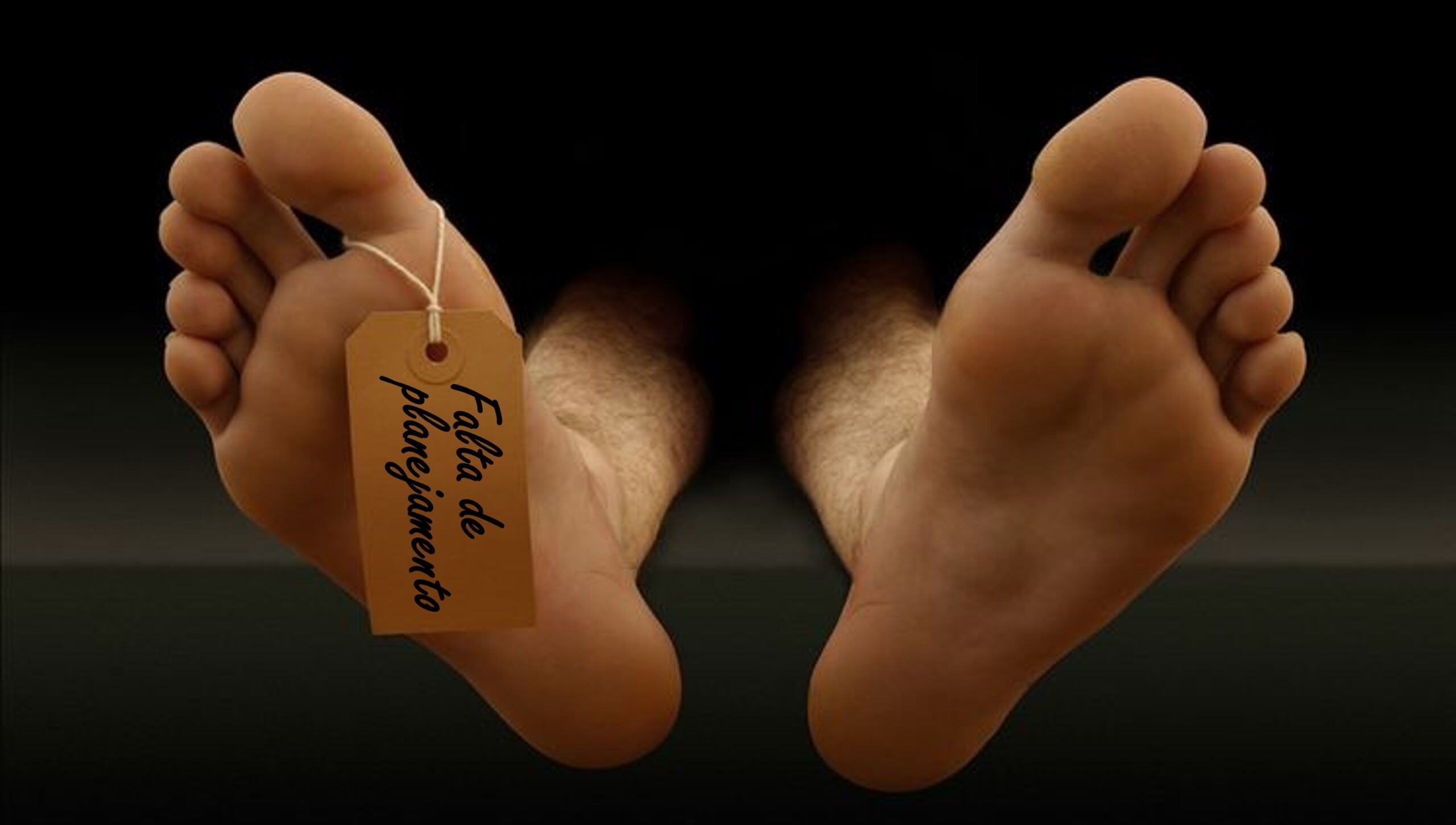 Foto dos dois pés descalços de um homem deitado em uma maca, como se estivesse em um necrotério. Pendurado no seu dedão do pé, uma etiqueta onde se lê: "Falta de Planejamento", como se fosse sua causa mortis, numa alusão à ideia central do texto sobre Autópsia Prévia.