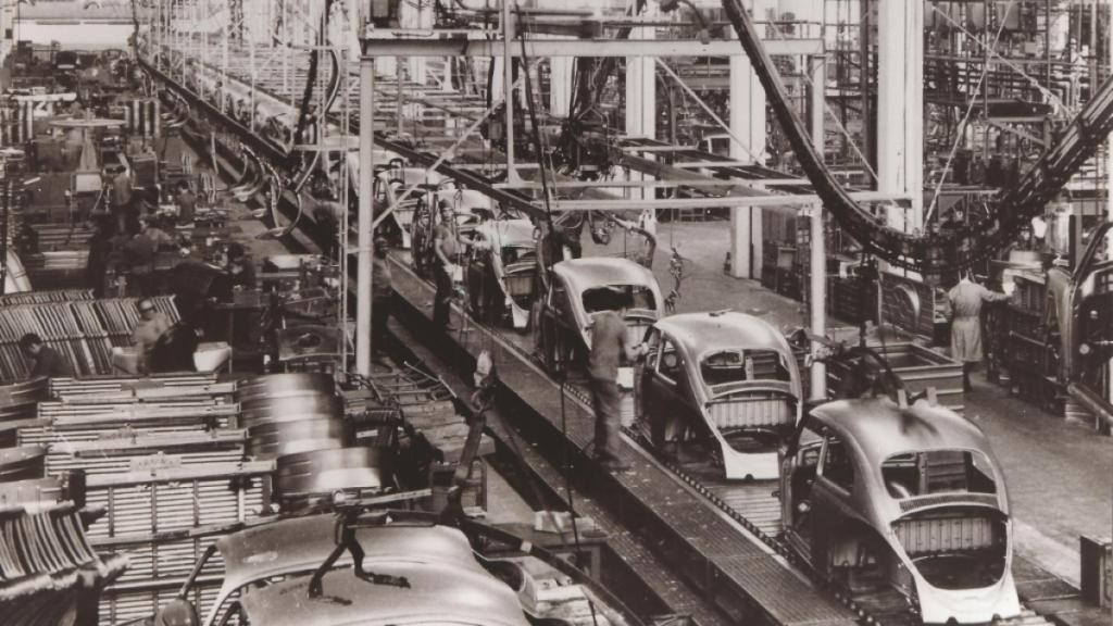 Foto em preto e branco com uma panorâmica de uma fábrica de automóveis da Volkswagen, construída há mais de 60 anos.