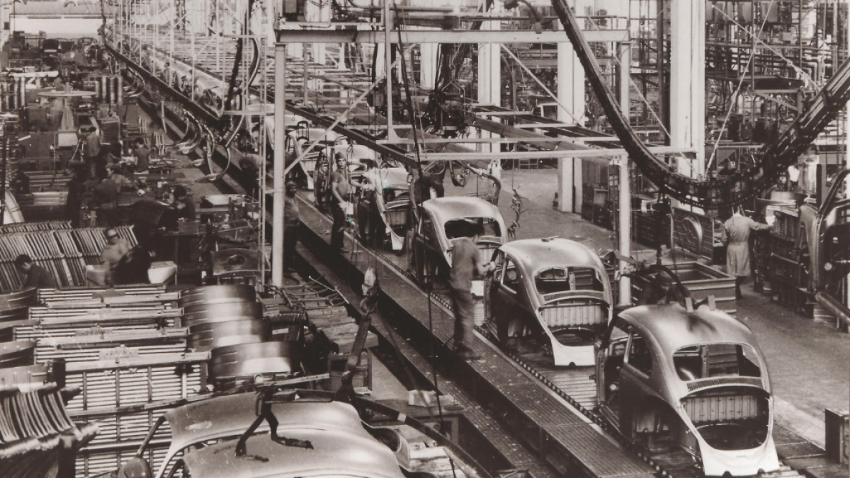 Foto em preto e branco com uma panorâmica de uma fábrica de automóveis da Volkswagen, construída há mais de 60 anos.